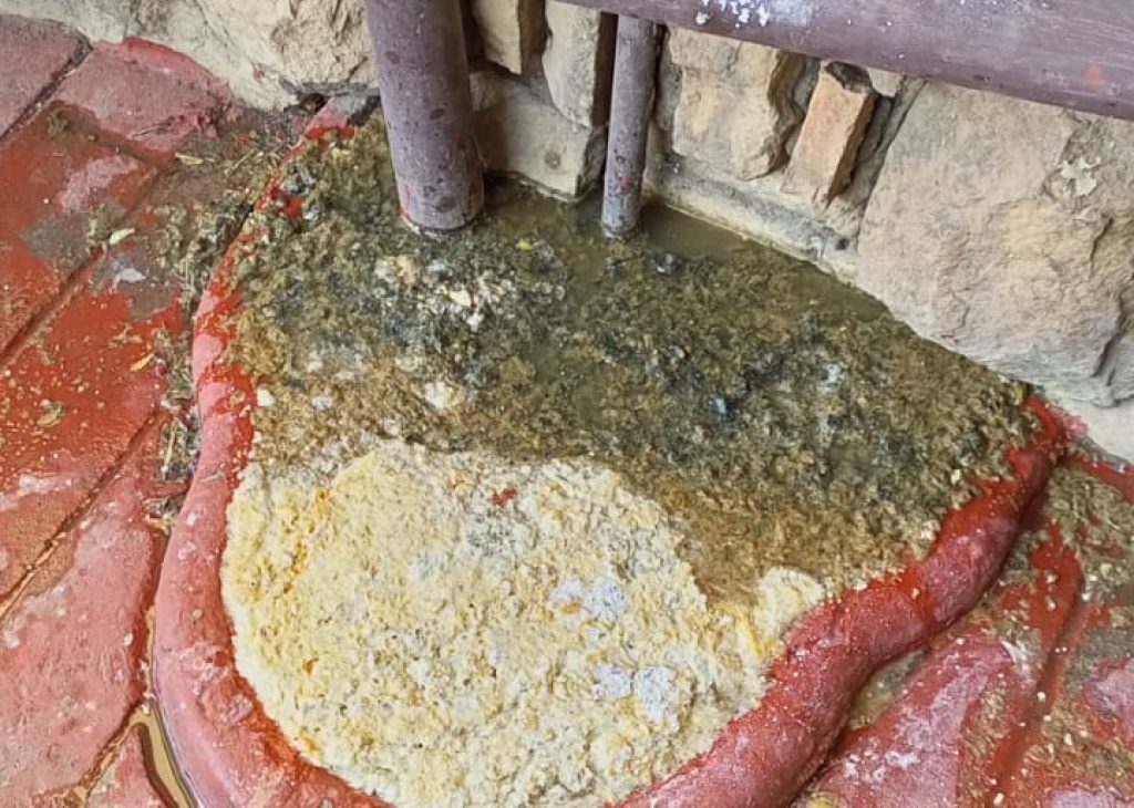 A plumber using a plunger to unclog a blocked drain.